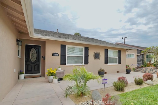 7642 Rhone Ln, Huntington Beach, CA 92647 - property entrance featuring stucco siding and a shingled roof