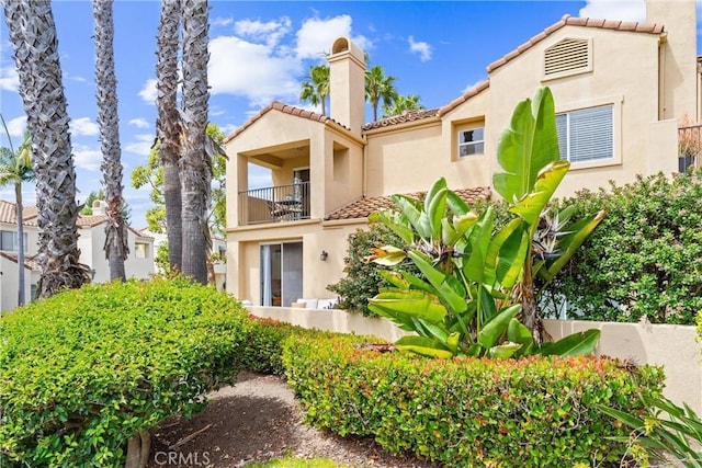 3 Fleurance St, Laguna Niguel, CA 92677 - rear view of house featuring a balcony, a tiled roof, stucco siding, and a chimney