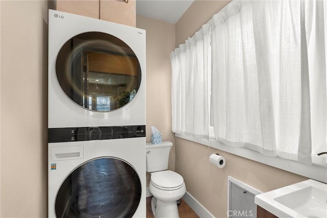 602 Stanley Ave, Long Beach, CA 90814 - bathroom featuring estacked washer and dryer, toilet, and baseboards