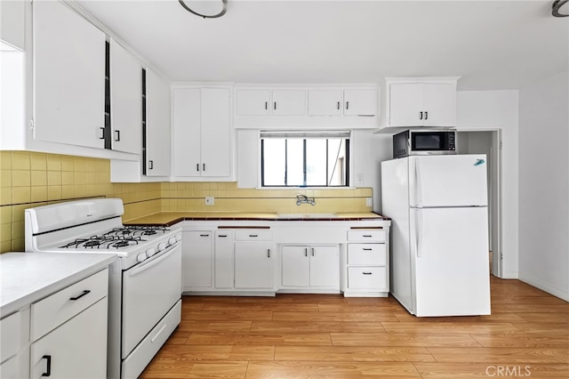 1634 Bayview Dr, Hermosa Beach, CA 90254 - kitchen featuring white appliances, a sink, white cabinetry, and light wood-type flooring