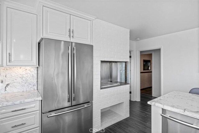1000 Park Ave, Cayucos, CA 93430 - kitchen with freestanding refrigerator, white cabinets, light stone countertops, and dark wood-style flooring