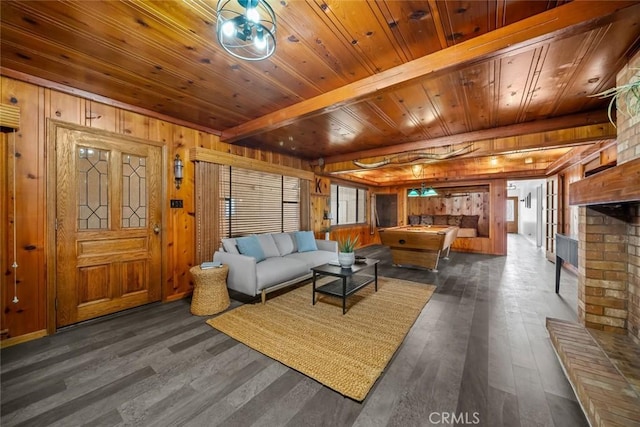 1000 Park Ave, Cayucos, CA 93430 - living room featuring dark wood-style flooring, wood walls, wooden ceiling with exposed beams, and a brick fireplace