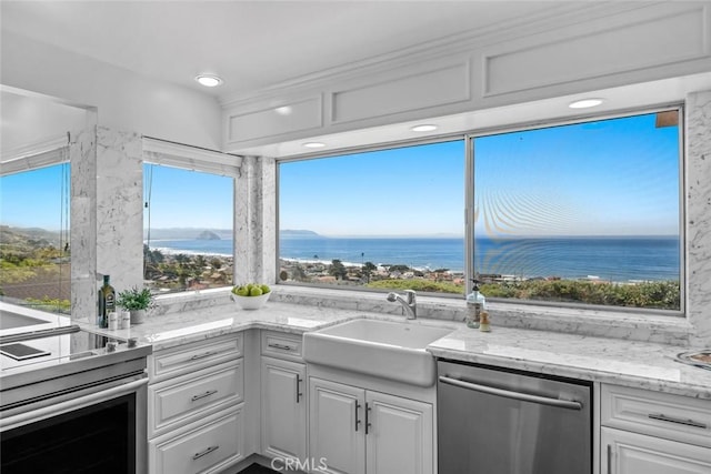 1000 Park Ave, Cayucos, CA 93430 - kitchen with appliances with stainless steel finishes, a sink, white cabinetry, and a water view