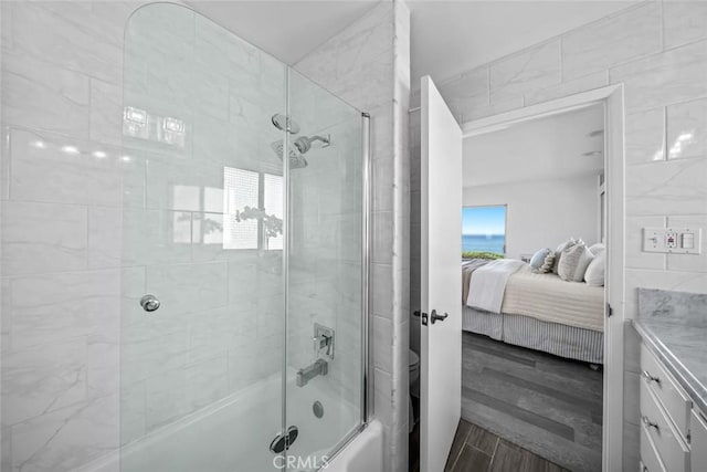 1000 Park Ave, Cayucos, CA 93430 - ensuite bathroom with combined bath / shower with glass door, wood finished floors, vanity, tile walls, and toilet