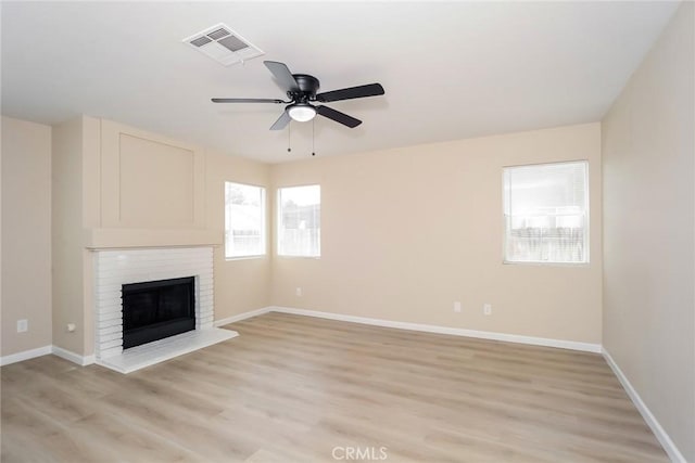 44124 Sundance Ct, Lancaster, CA 93535 - unfurnished living room featuring a ceiling fan, a brick fireplace, light wood-style flooring, and baseboards