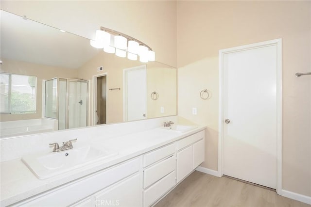 44124 Sundance Ct, Lancaster, CA 93535 - bathroom featuring a shower stall, double vanity, wood finished floors, a garden tub, and baseboards