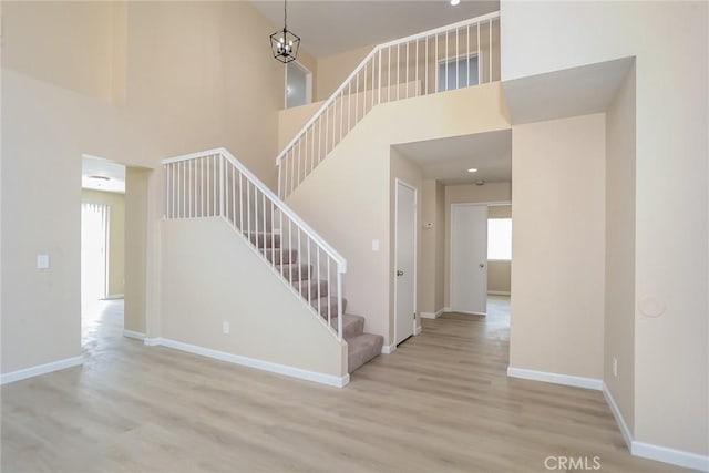 44124 Sundance Ct, Lancaster, CA 93535 - staircase with a high ceiling, wood finished floors, and baseboards