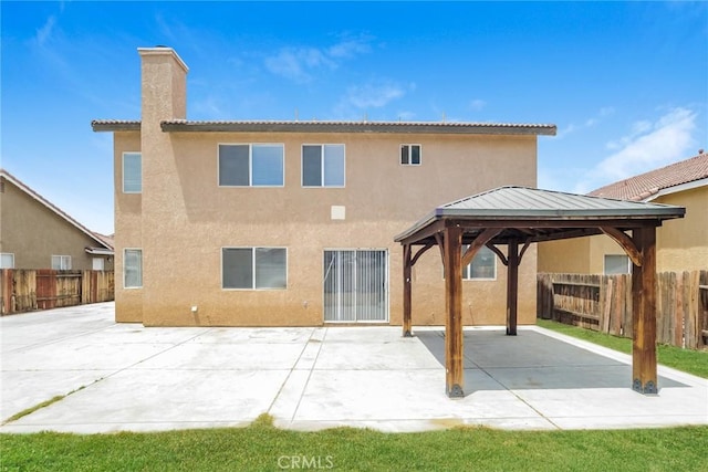 44124 Sundance Ct, Lancaster, CA 93535 - back of property with stucco siding, a gazebo, a chimney, and a patio