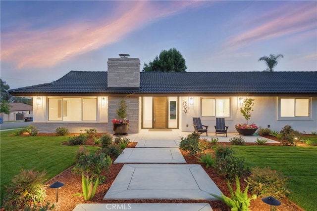 830 Huerta Verde Rd, Glendora, CA 91741 - back of property at dusk featuring a chimney, a yard, stucco siding, and brick siding