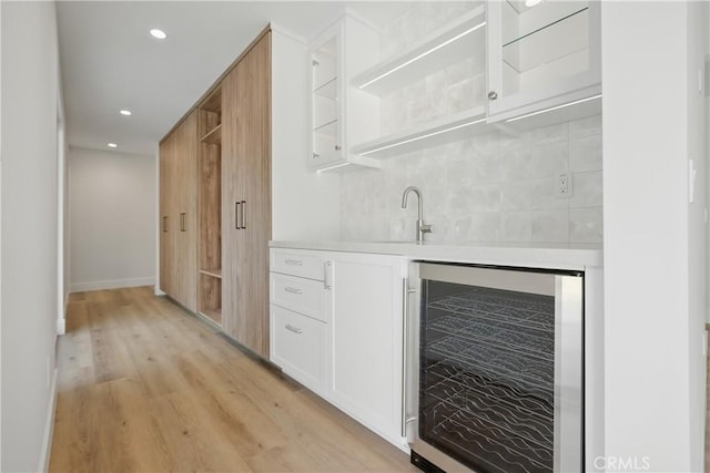 830 Huerta Verde Rd, Glendora, CA 91741 - indoor wet bar with beverage cooler, light wood-style flooring, decorative backsplash, recessed lighting, and baseboards