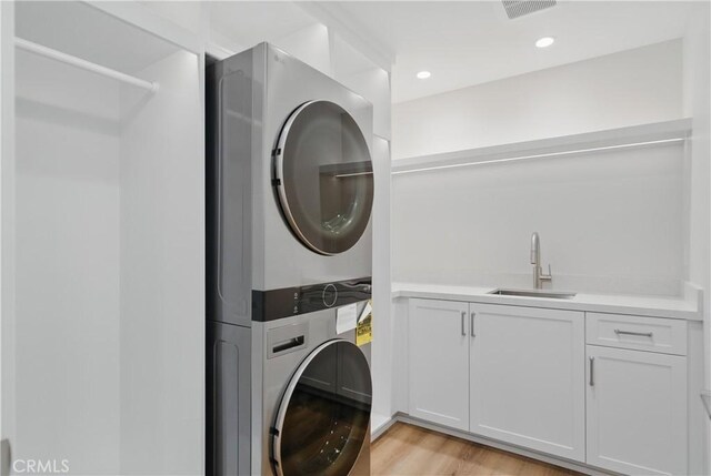 830 Huerta Verde Rd, Glendora, CA 91741 - washroom with stacked washer / drying machine, cabinet space, light wood finished floors, and recessed lighting