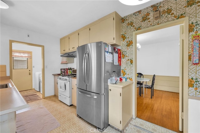 2121 Westminster Ave, Alhambra, CA 91803 - kitchen with white range with gas stovetop, freestanding refrigerator, wallpapered walls, cream cabinetry, and under cabinet range hood