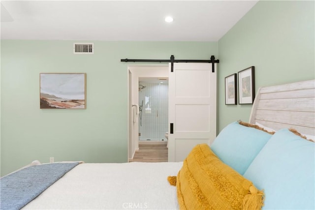 1425 E 2nd St Unit 101, Long Beach, CA 90802 - bedroom featuring a barn door, recessed lighting, connected bathroom, and wood finished floors