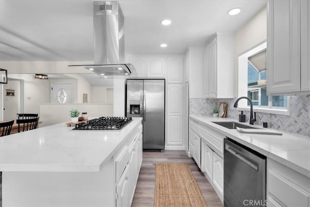 20512 Wayne Ave, Torrance, CA 90503 - kitchen featuring stainless steel appliances, island range hood, a sink, white cabinetry, and light wood-style floors