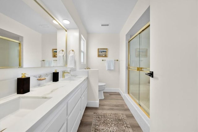 20512 Wayne Ave, Torrance, CA 90503 - bathroom with toilet, a shower stall, wood finished floors, double vanity, and baseboards