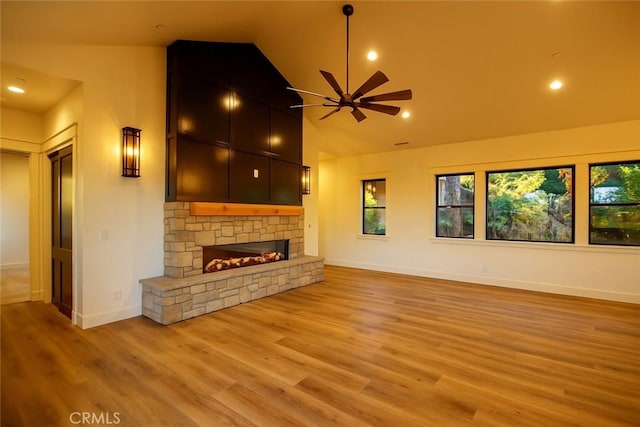 26603 Windward Rd, Lake Arrowhead, CA 92352 - unfurnished living room with lofted ceiling, a ceiling fan, a stone fireplace, plenty of natural light, and light wood finished floors
