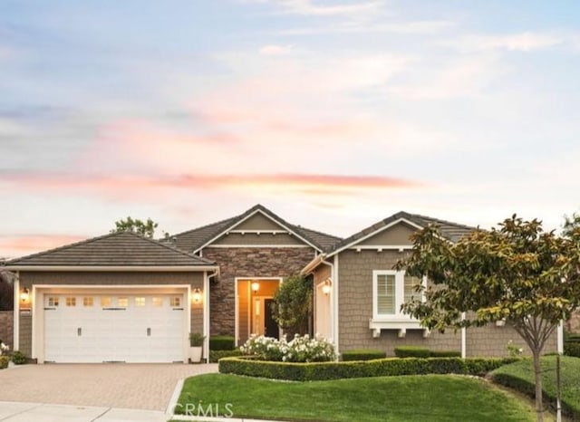 1801 Louise Ln, Nipomo, CA 93444 - view of front of home featuring driveway, a yard, an attached garage, and stone siding