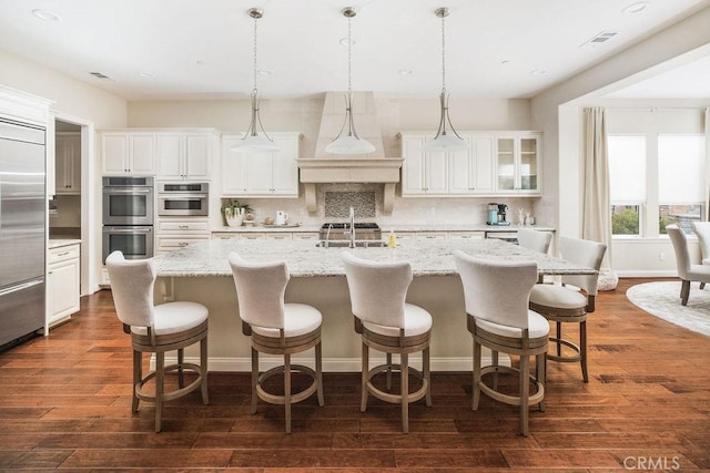1801 Louise Ln, Nipomo, CA 93444 - kitchen featuring appliances with stainless steel finishes, tasteful backsplash, white cabinets, dark wood-style floors, and a center island with sink
