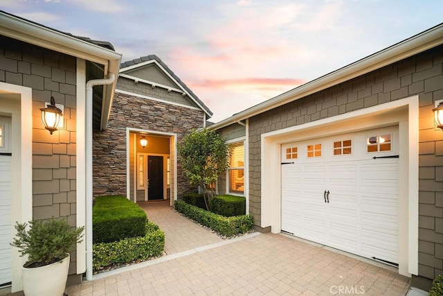 1801 Louise Ln, Nipomo, CA 93444 - exterior entry at dusk featuring stone siding and an attached garage