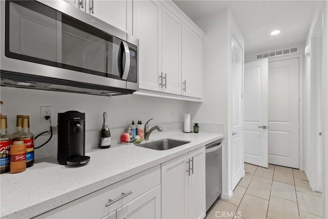 28341 Heather Green Way, Menifee, CA 92584 - kitchen with appliances with stainless steel finishes, a sink, white cabinets, recessed lighting, and light stone countertops
