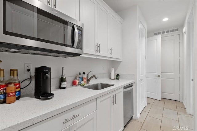 28341 Heather Green Way, Menifee, CA 92584 - kitchen with stainless steel appliances, white cabinetry, light tile patterned floors, recessed lighting, and light stone counters