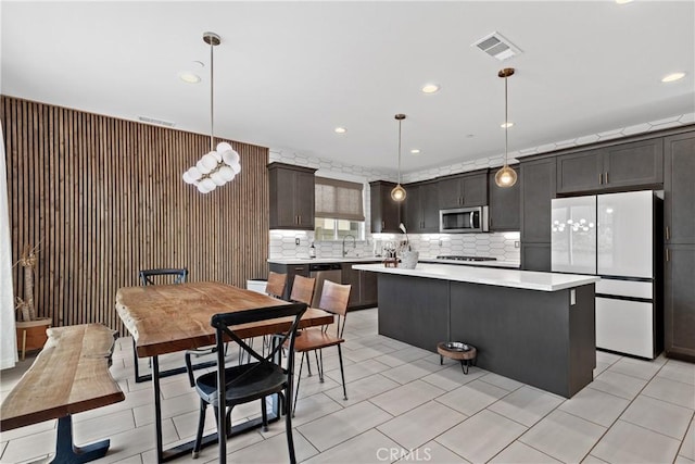 28341 Heather Green Way, Menifee, CA 92584 - kitchen featuring stainless steel appliances, light countertops, a kitchen island, backsplash, and hanging light fixtures