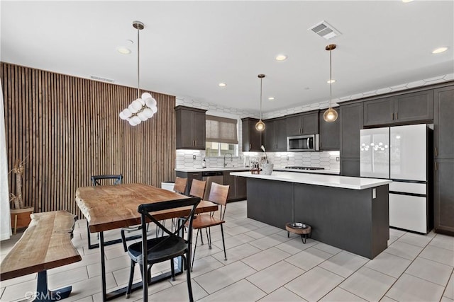 28341 Heather Green Way, Menifee, CA 92584 - kitchen featuring stainless steel microwave, freestanding refrigerator, light countertops, a center island, and decorative backsplash