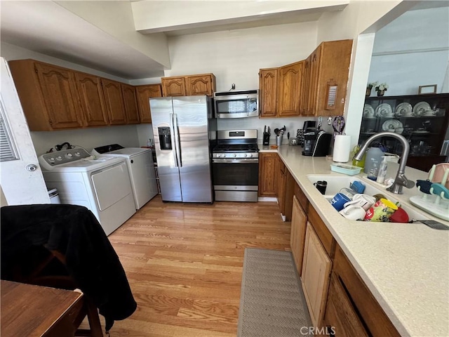 1521 Bridge St, Los Angeles, CA 90033 - kitchen featuring stainless steel appliances, independent washer and dryer, brown cabinetry, a sink, and light countertops