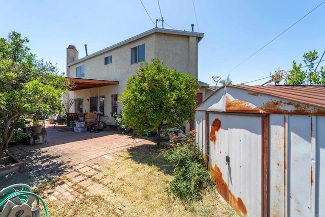 4643 Cherokee Ave, San Diego, CA 92116 - back of house with a patio, a chimney, stucco siding, and a storage unit