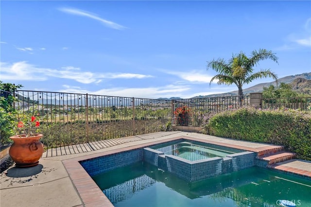12045 Falcon Crest Way, Porter Ranch, CA 91326 - view of swimming pool featuring a mountain view, a pool with connected hot tub, and a fenced backyard