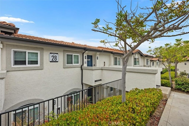 30902 Clubhouse Dr Unit 28C, Laguna Niguel, CA 92677 - view of property exterior with a balcony, stucco siding, and a tile roof