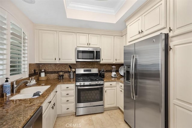 30902 Clubhouse Dr Unit 28C, Laguna Niguel, CA 92677 - kitchen featuring appliances with stainless steel finishes, a sink, a tray ceiling, light tile patterned floors, and dark stone countertops