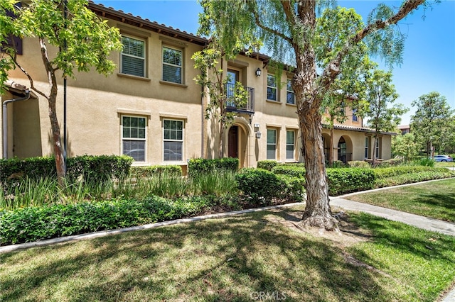 61 Silverado, Irvine, CA 92618 - mediterranean / spanish home featuring stucco siding, a front yard, and a balcony