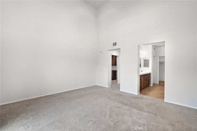 61 Silverado, Irvine, CA 92618 - unfurnished bedroom featuring a walk in closet, light carpet, a high ceiling, a closet, and connected bathroom