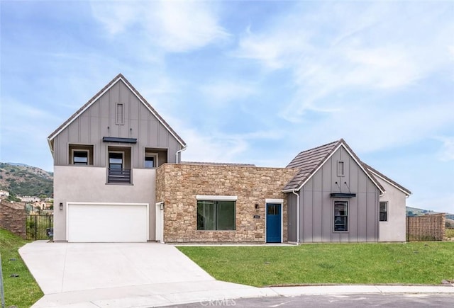 18510 Boulder Blf, Silverado, CA 92676 - view of front of house with board and batten siding, a garage, driveway, and stone siding