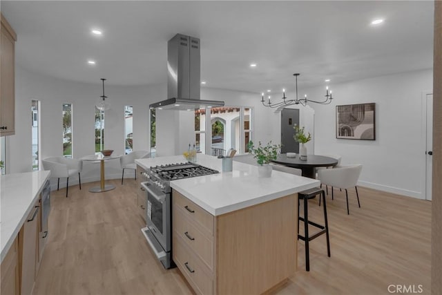 3649 Mount Vernon Dr, View Park, CA 90008 - kitchen with high end stove, island range hood, light brown cabinetry, a kitchen bar, and light wood-style flooring