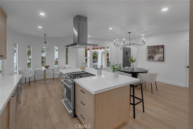 3649 Mount Vernon Dr, View Park, CA 90008 - kitchen with high end range, island range hood, light brown cabinetry, a breakfast bar area, and light wood-style floors