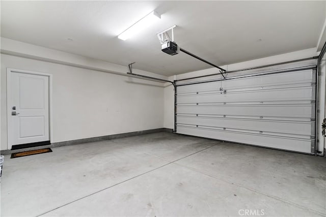12392 Sandy Ct, Whittier, CA 90602 - garage featuring a garage door opener and baseboards