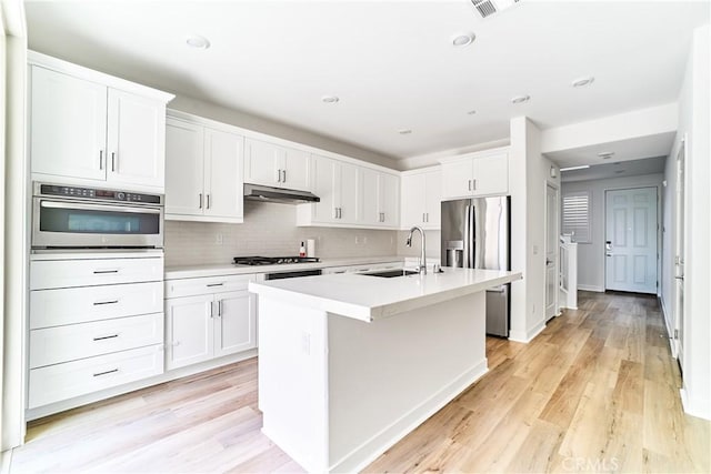 12392 Sandy Ct, Whittier, CA 90602 - kitchen with stainless steel appliances, light countertops, white cabinets, an island with sink, and recessed lighting