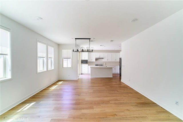 12392 Sandy Ct, Whittier, CA 90602 - unfurnished living room with light wood-style floors and a chandelier