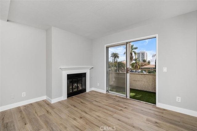 645 Chestnut Ave Unit 202, Long Beach, CA 90802 - unfurnished living room with wood finished floors, a glass covered fireplace, and baseboards