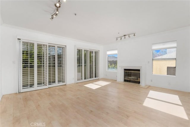 4426 Ventura Canyon Ave Unit 204, Sherman Oaks, CA 91423 - unfurnished living room with track lighting, crown molding, healthy amount of natural light, wood finished floors, and a glass covered fireplace
