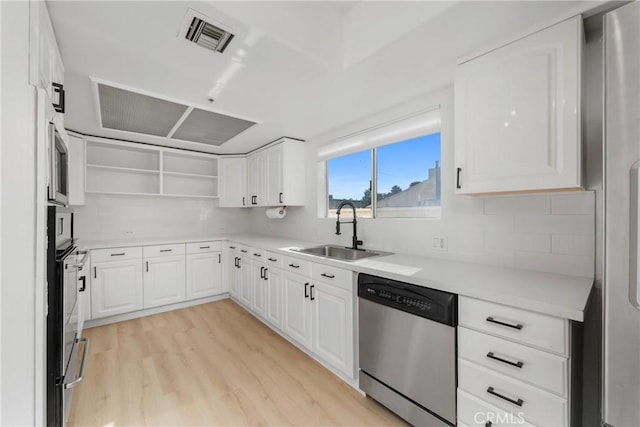 4426 Ventura Canyon Ave Unit 204, Sherman Oaks, CA 91423 - kitchen with appliances with stainless steel finishes, a sink, light wood-type flooring, backsplash, and white cabinetry