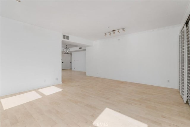 4426 Ventura Canyon Ave Unit 204, Sherman Oaks, CA 91423 - unfurnished living room with light wood-style floors, rail lighting, a chandelier, and crown molding