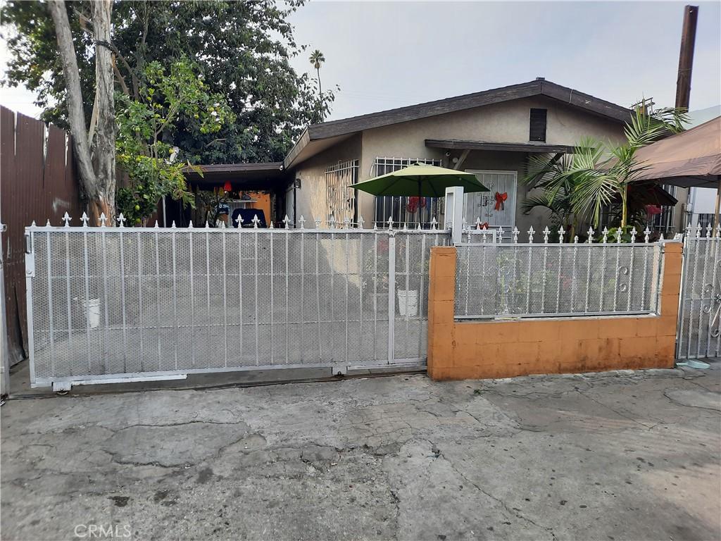 5727 Bandera St, Los Angeles, CA 90058 - view of front of property with a fenced front yard, stucco siding, and a gate
