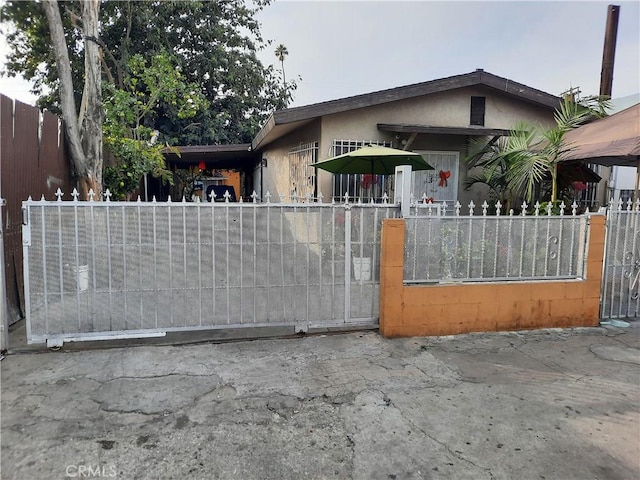 5727 Bandera St, Los Angeles, CA 90058 - view of front of property with a fenced front yard, stucco siding, and a gate
