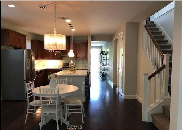 639 Burnt Ranch Way, Chico, CA 95973 - kitchen featuring light countertops, appliances with stainless steel finishes, a center island, dark wood-style floors, and decorative light fixtures