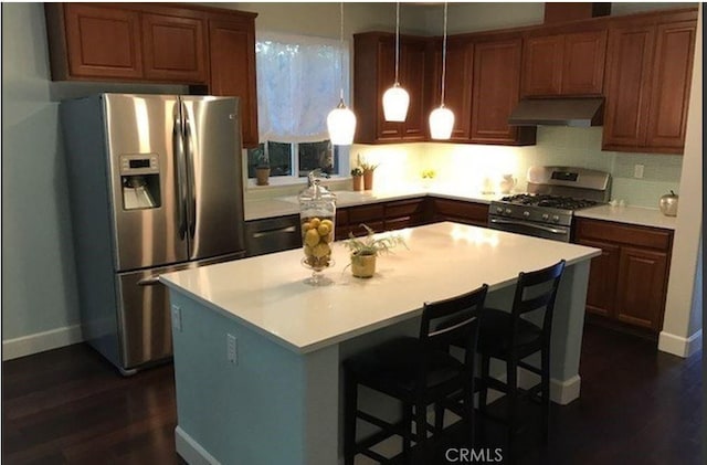 639 Burnt Ranch Way, Chico, CA 95973 - kitchen featuring appliances with stainless steel finishes, under cabinet range hood, dark wood-style floors, light countertops, and a center island