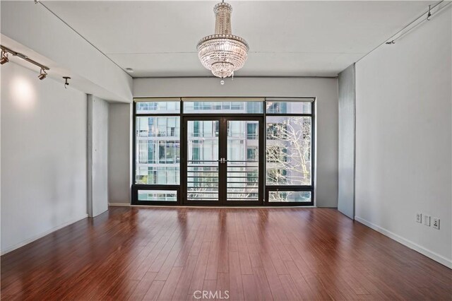 1111 S Grand Ave Unit 702, Los Angeles, CA 90015 - spare room with a chandelier, wood finished floors, french doors, and baseboards