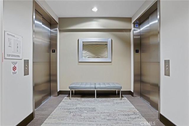 1111 S Grand Ave Unit 702, Los Angeles, CA 90015 - hall featuring elevator, wood finished floors, and baseboards